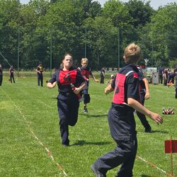 Kinder in Sportkleidung spielen auf dem Rasen und haben Spaß bei einem Wettkampf im Freien. | © Name