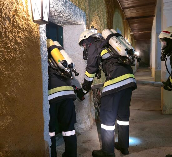 Der Atemschutztrupp der FF Kasten öffnet vorsichtig die Tür zum verrauchten Gebäude