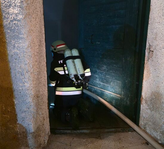 Aufgrund der schlechten Sicht im verrauchten Gebäude geht der Atemschutztrupp auf Knien