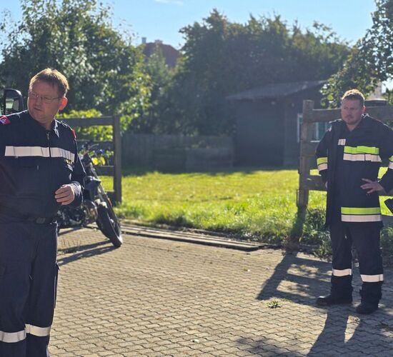 Der Ausbilder zeigt auf eine Grafik zu Mindestabständen im Ortsgebiet die an einem Fahrzeug aufgeklebt ist.