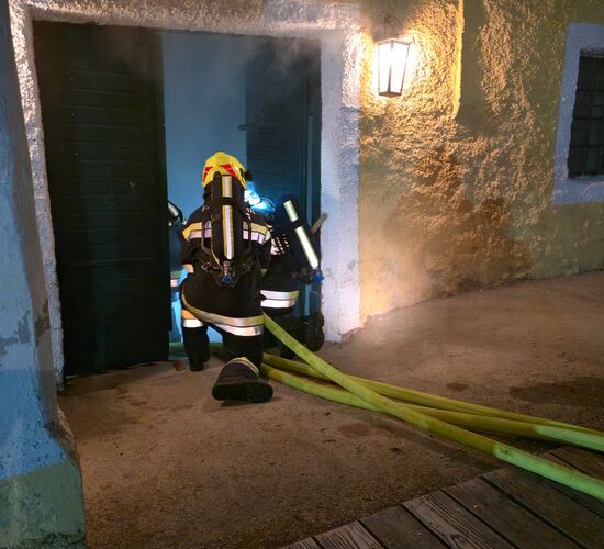 Der Atemschutztrupp der FF Perersdorf geht auf Knien in das verrauchte Gebäude