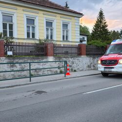 Feuerwehrleute in Schutzkleidung bereiten sich auf eine Einsatztätigkeit vor, während ein weiteres Einsatzfahrzeug eintrifft.